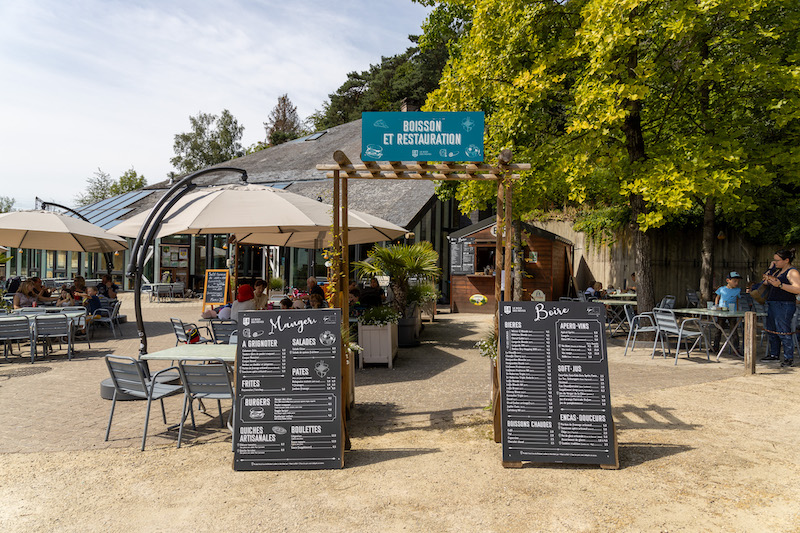 Photo de la terrasse de la brasserie remplie de personnes, avec les cartes mises en avant