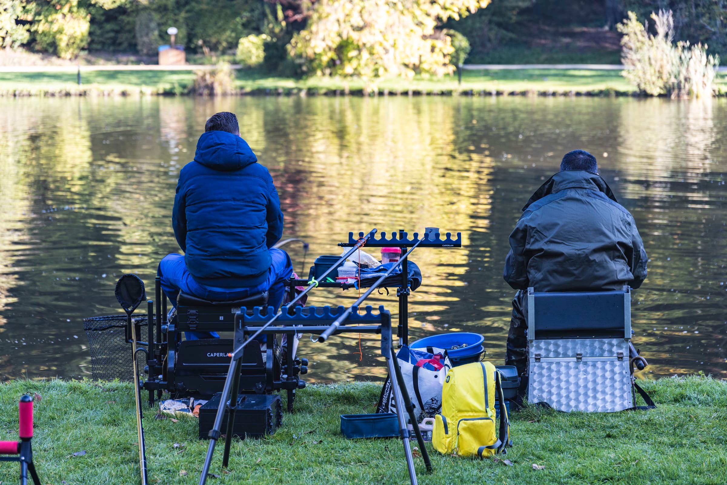 Photo vue de dos de 2 pêcheurs habillés chaudement autour du lac