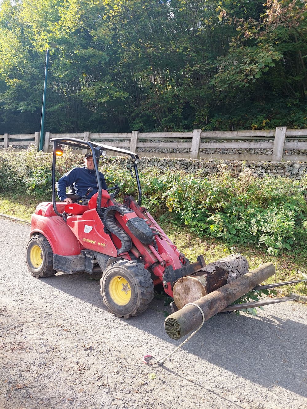 Photo d'un membre de l'équipe des Bois des Rêves dans un tracteur porteur des rondins de bois